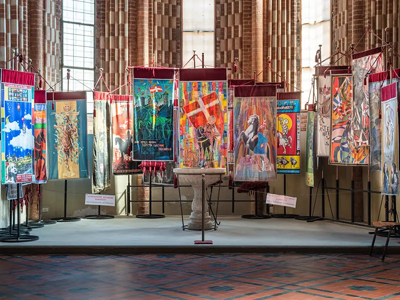 Exposition des drapes du Palio offertes à la Collégiale lors de la cérémonie médiévale de l'Offre du Palio.